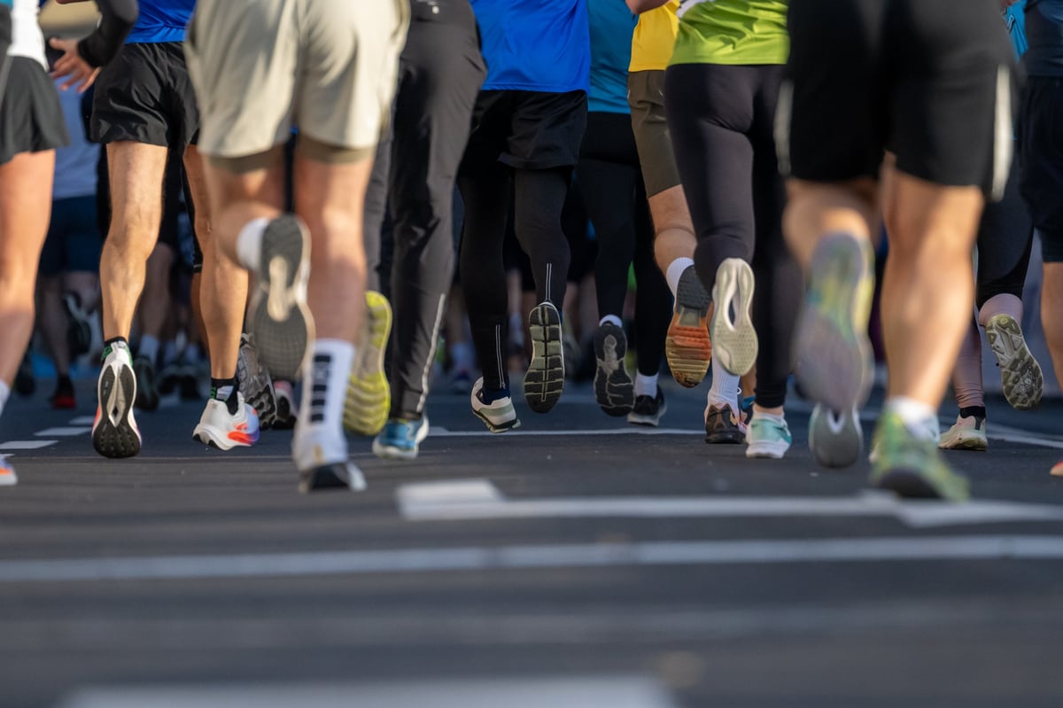 Runners in athletic clothing and shoes moving through the city