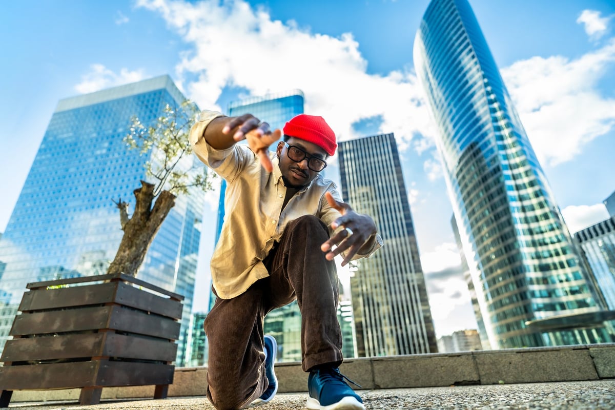 Man in casual streetwear and red beanie in an urban setting