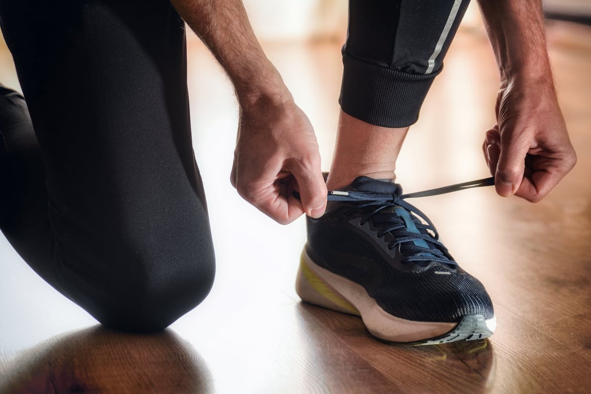Detail of a person tying a sneaker in a bright room
