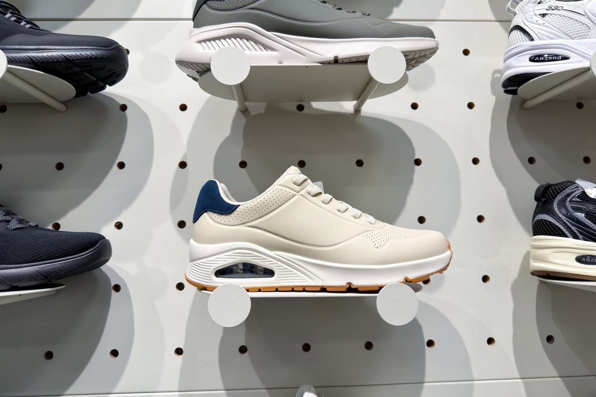 Diverse selection of sports shoes displayed on a store wall