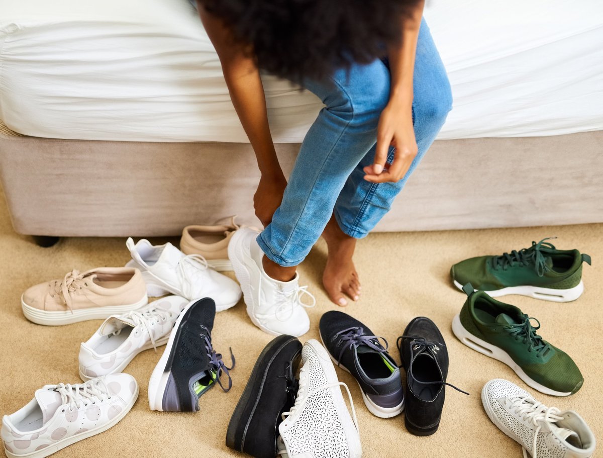 Woman comparing pairs of shoes while trying them on