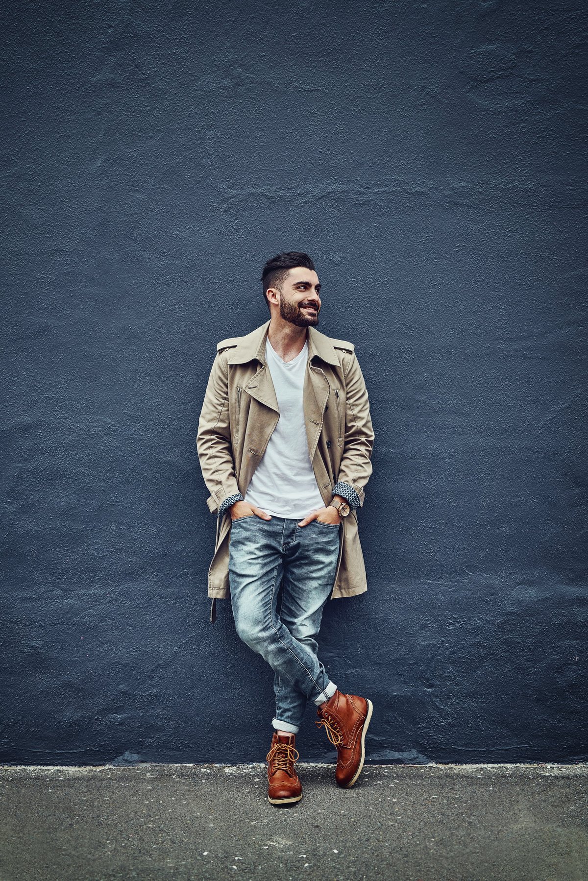 Young man in urban streetwear against a wall